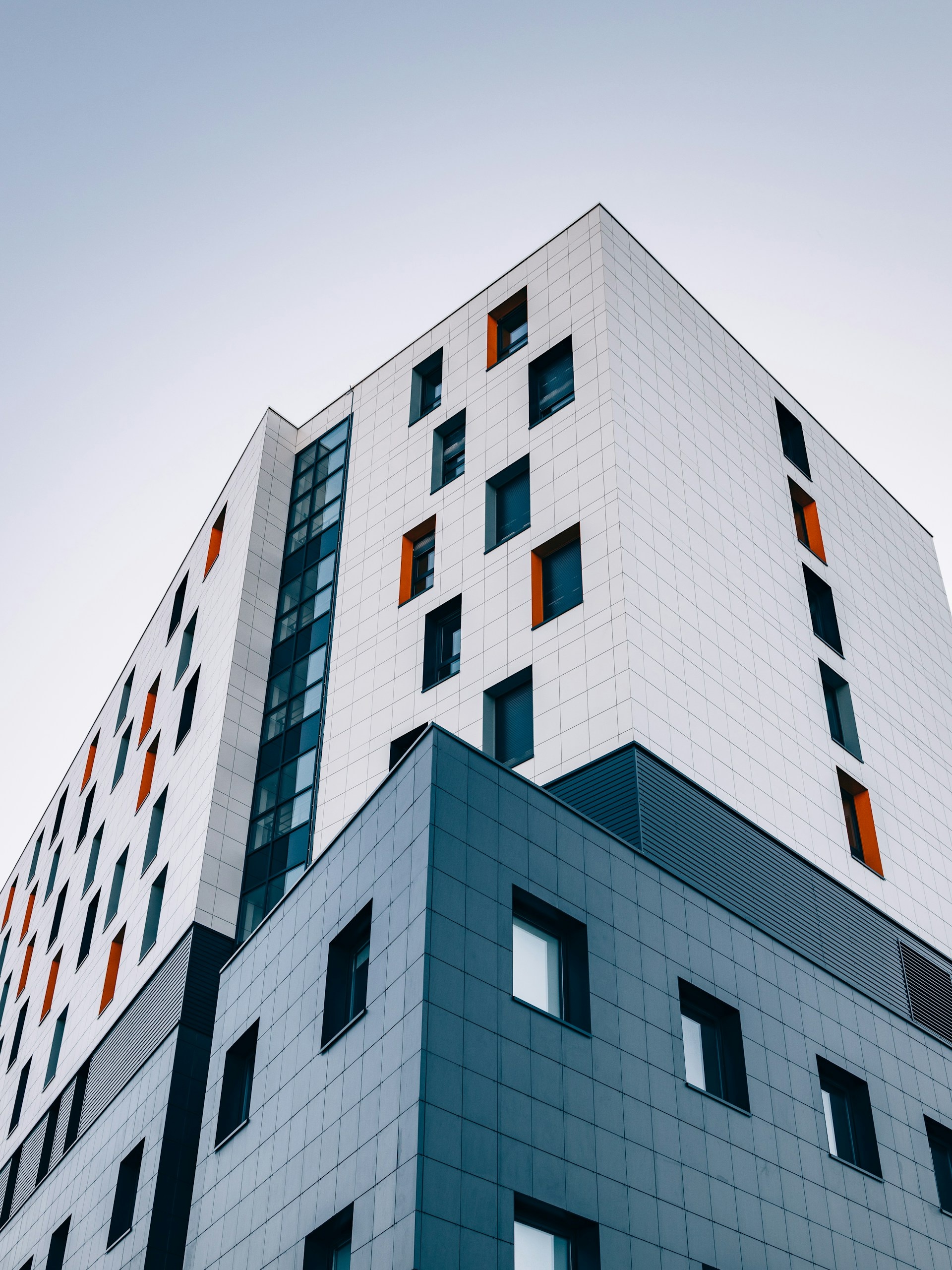 Immeuble moderne aux façades colorées sous un ciel nuageux