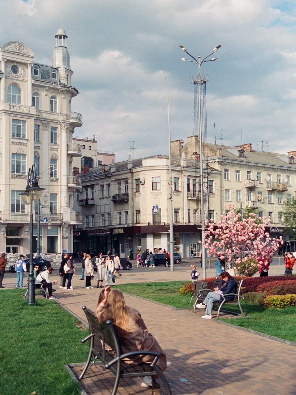 Espace vert urbain avec des bancs, des arbres et des passants