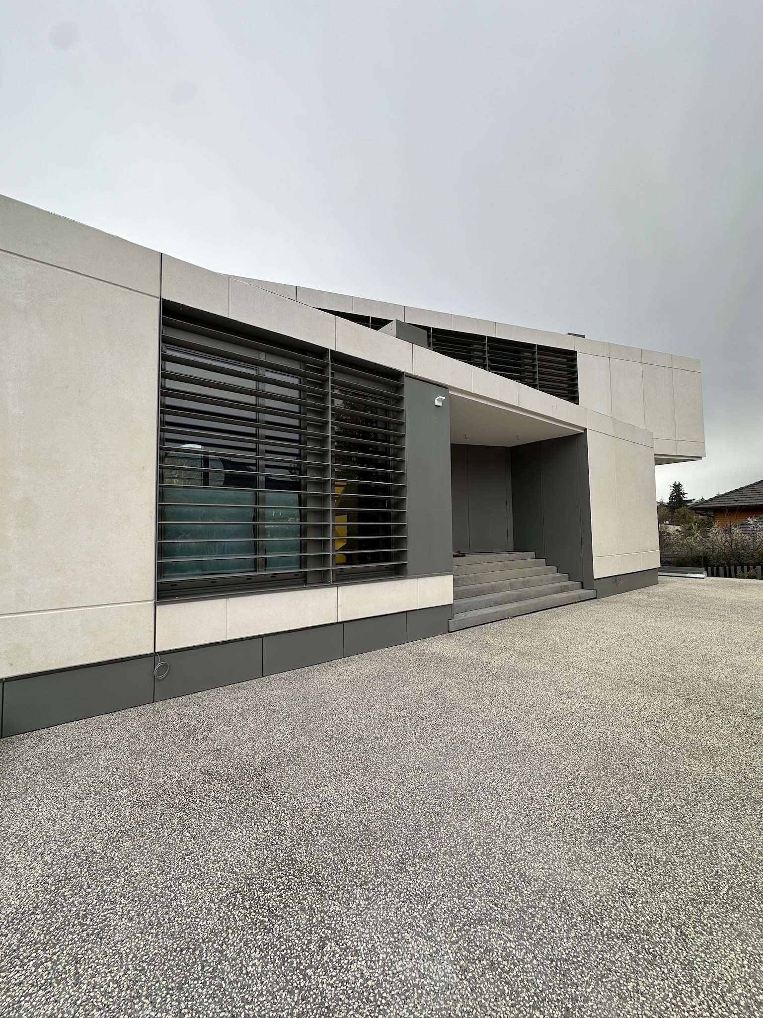 Brise-soleil métallique gris intégré à une résidence
