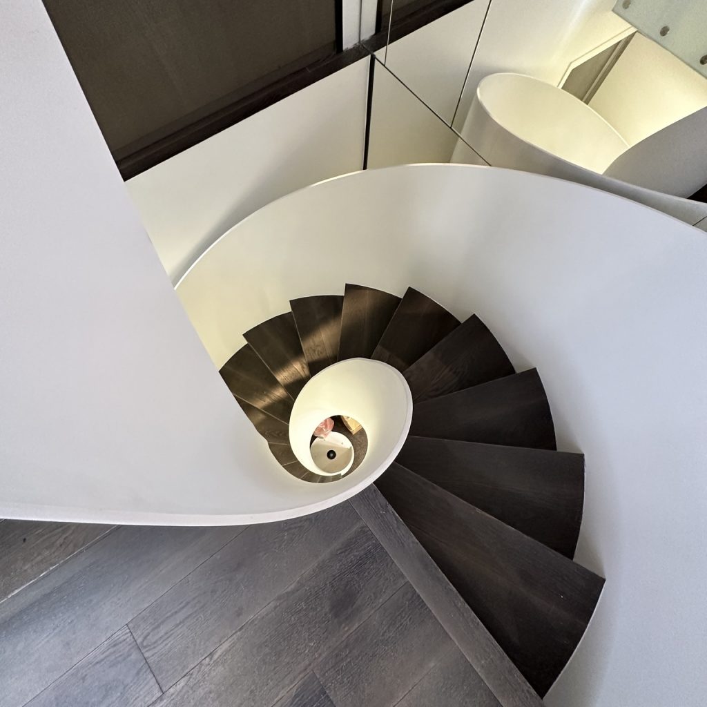 Escalier hélicoïdal métallique blanc avec des marches en bois