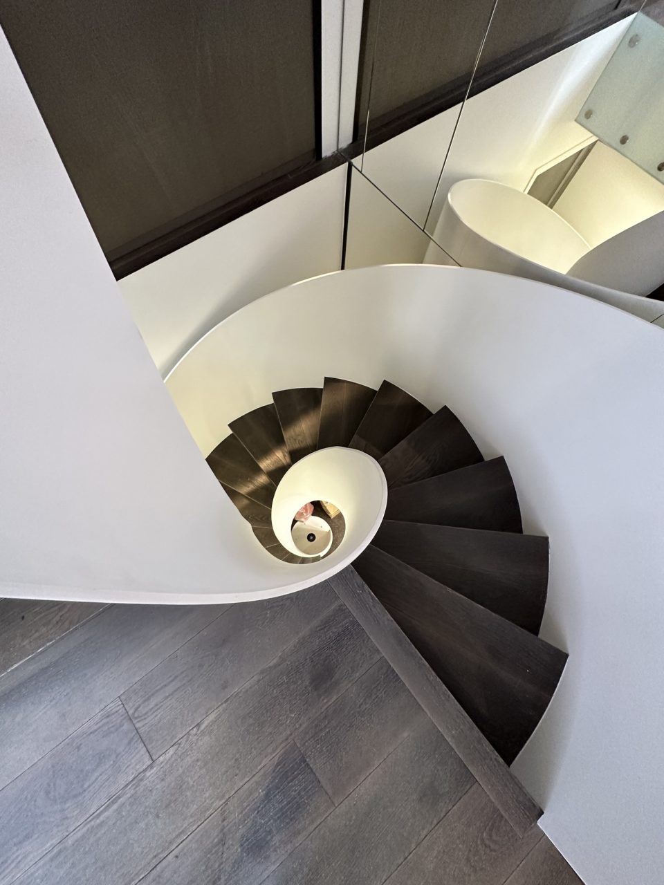 Escalier hélicoïdal métallique blanc avec des marches en bois