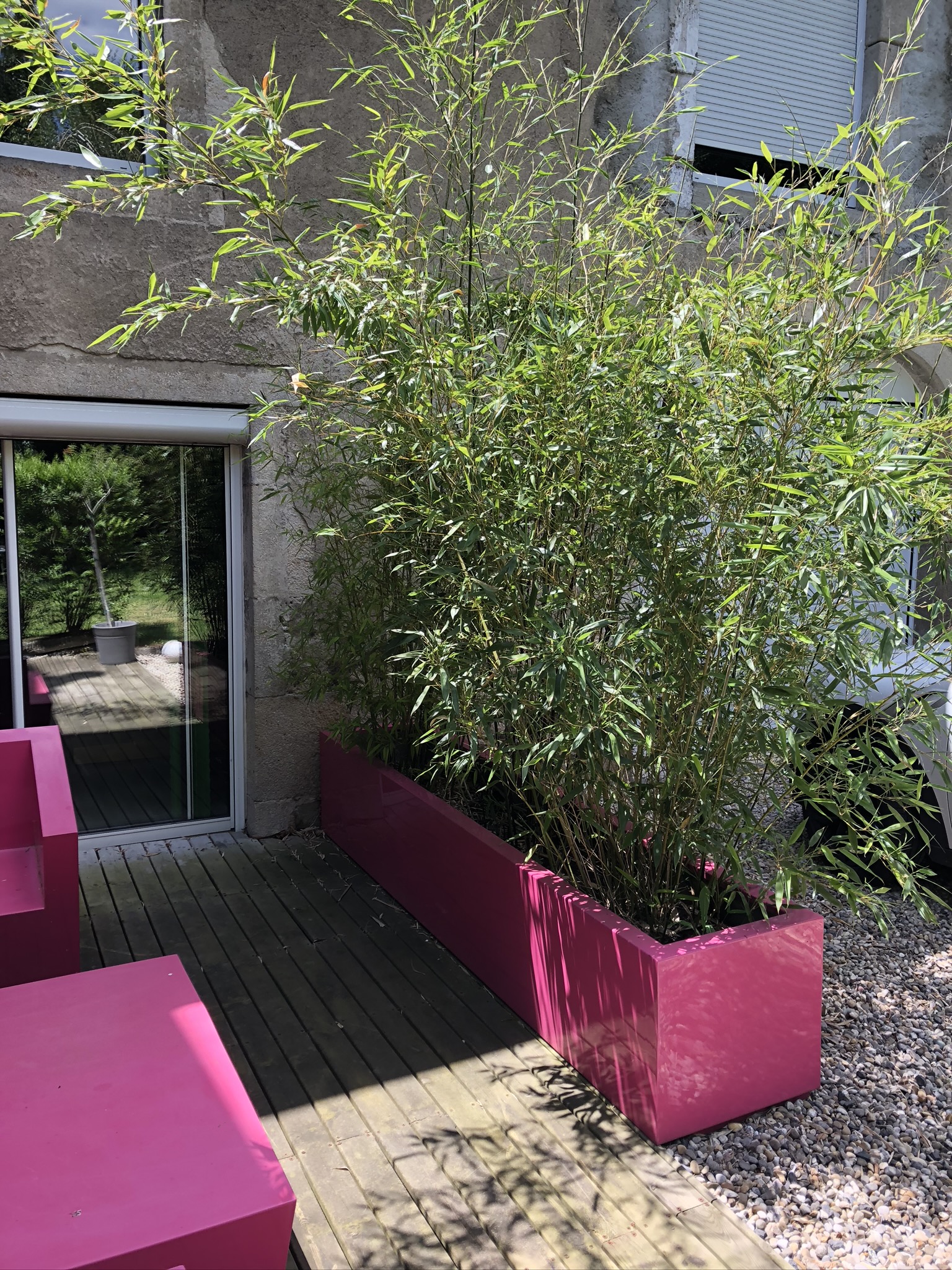 Terrasse extérieure possédant divers meubles de jardin métalliques roses