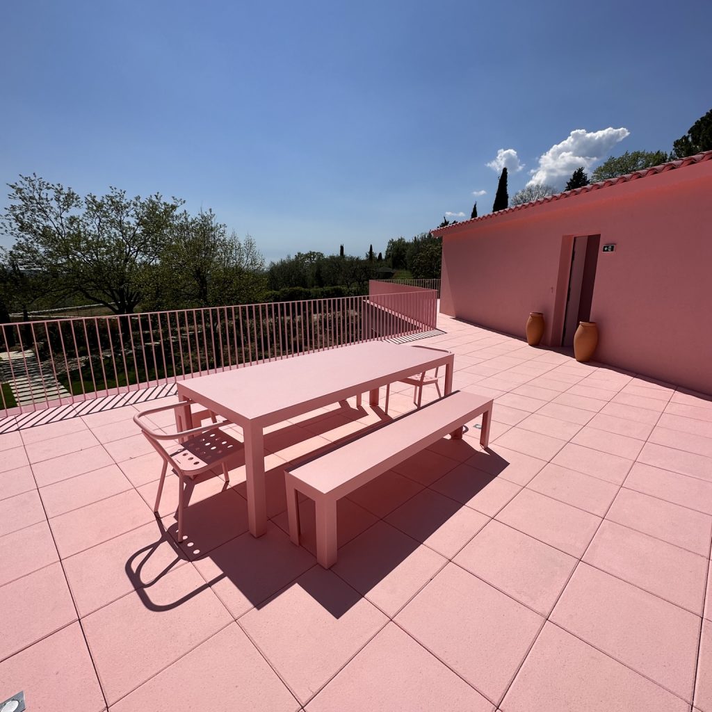 Terrasse extérieure possédant divers meubles de jardin métalliques roses
