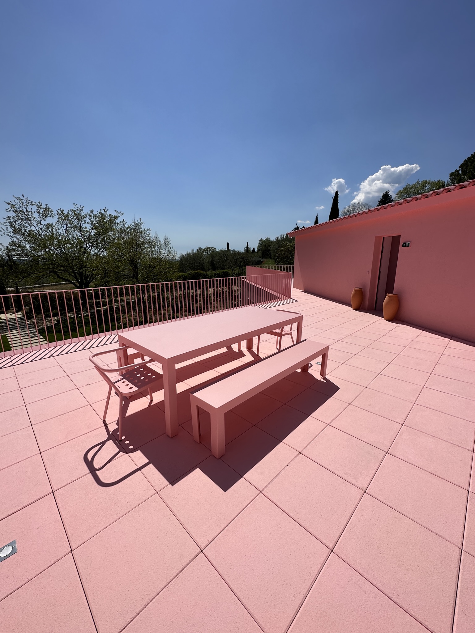 Terrasse extérieure possédant divers meubles de jardin métalliques roses