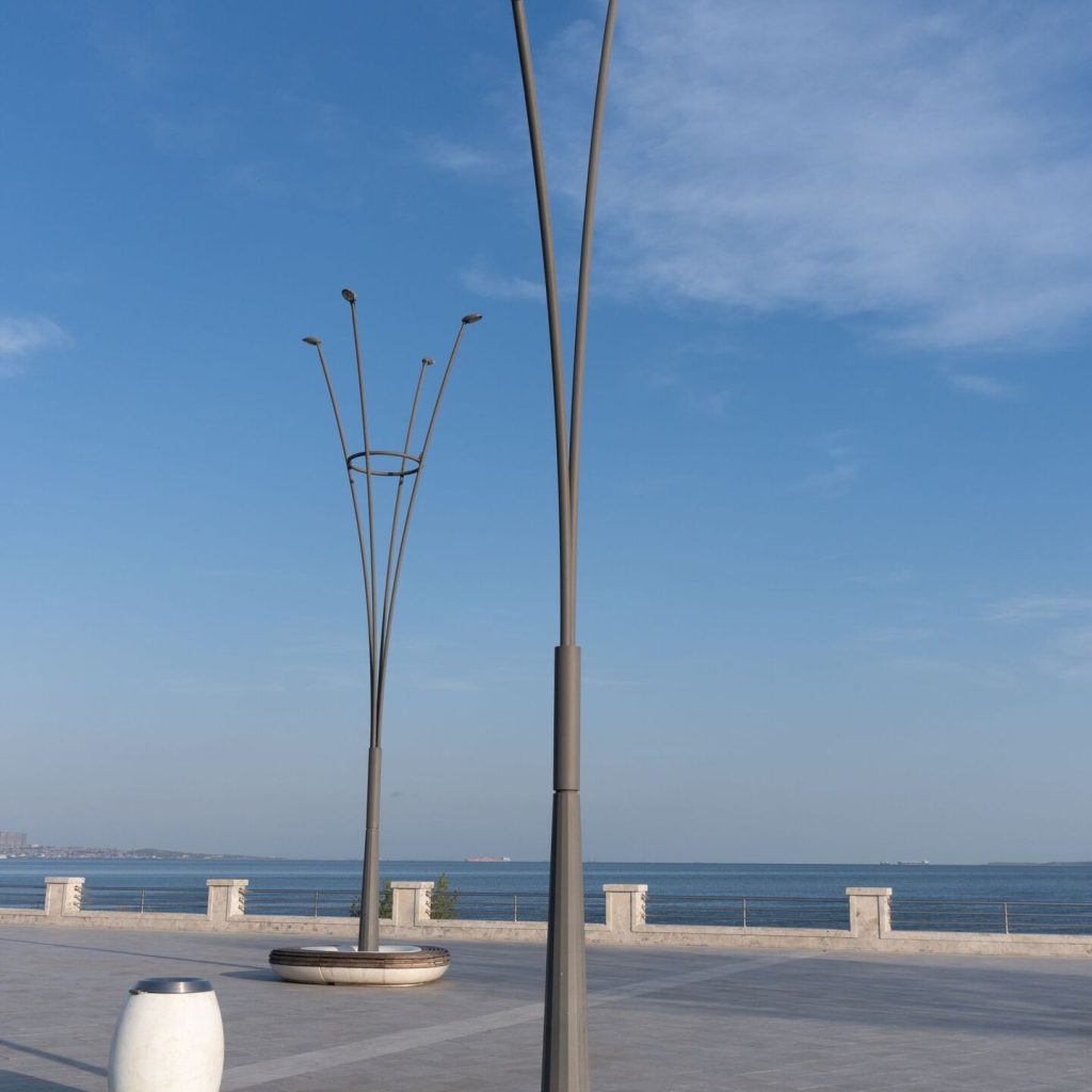 Lampadaires métalliques gris installés sur une rue piétonne au bord de la mer