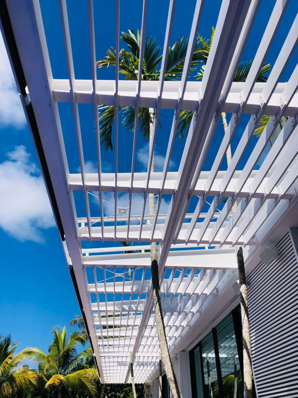 Pergola métallique blanche située au-dessus d'une terrasse extérieure