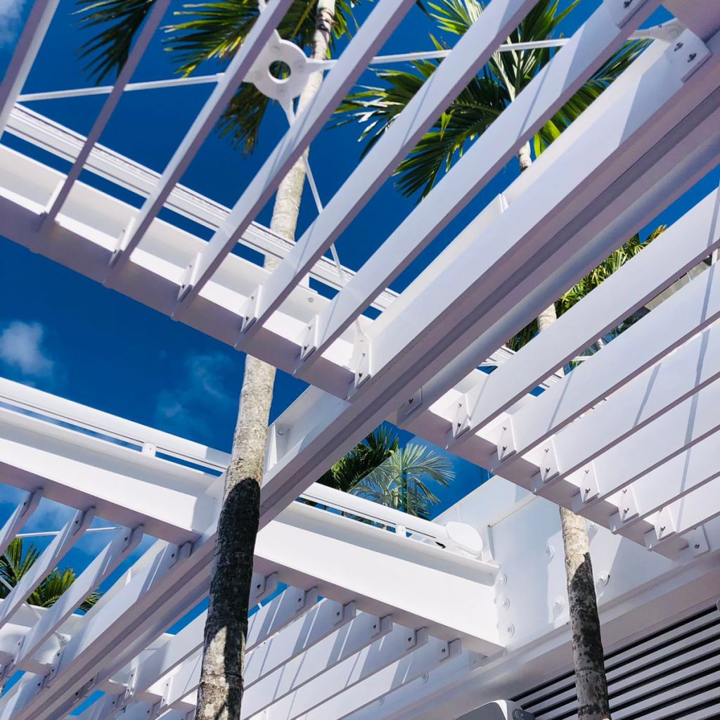 Pergola métallique blanche située au-dessus d'une terrasse extérieure