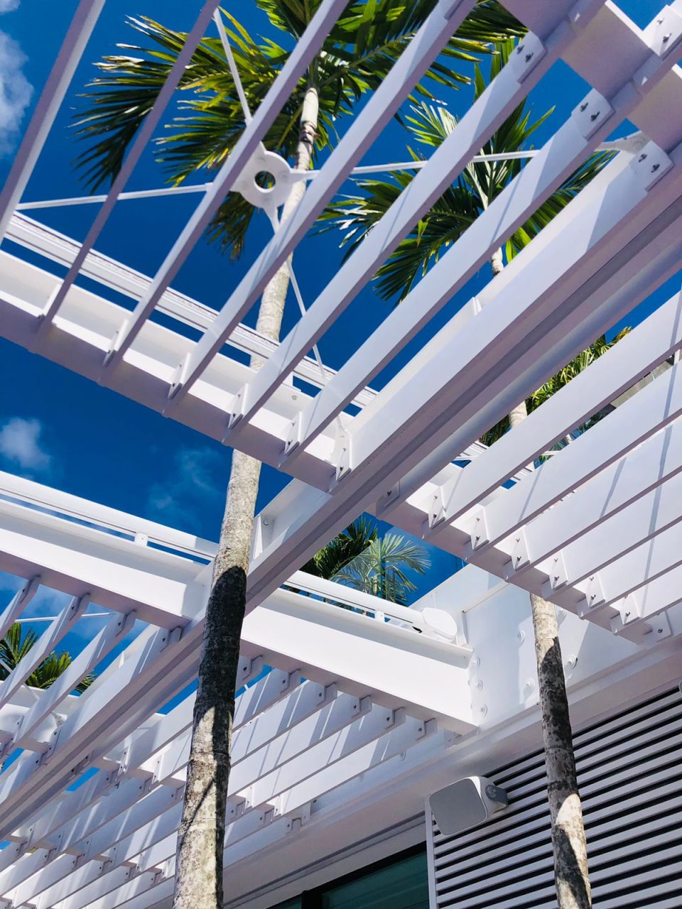 Pergola métallique blanche située au-dessus d'une terrasse extérieure