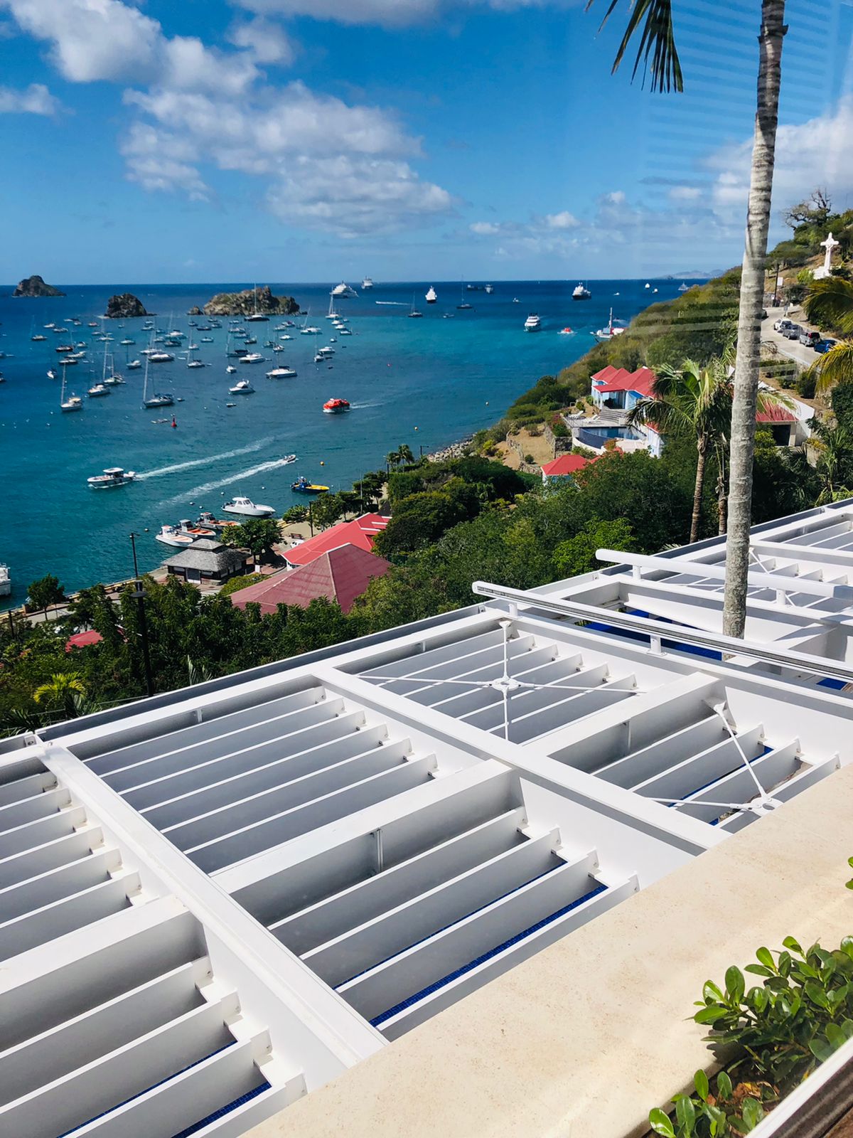 Pergola métallique blanche située au-dessus d'une terrasse extérieure avec une vue sur la mer