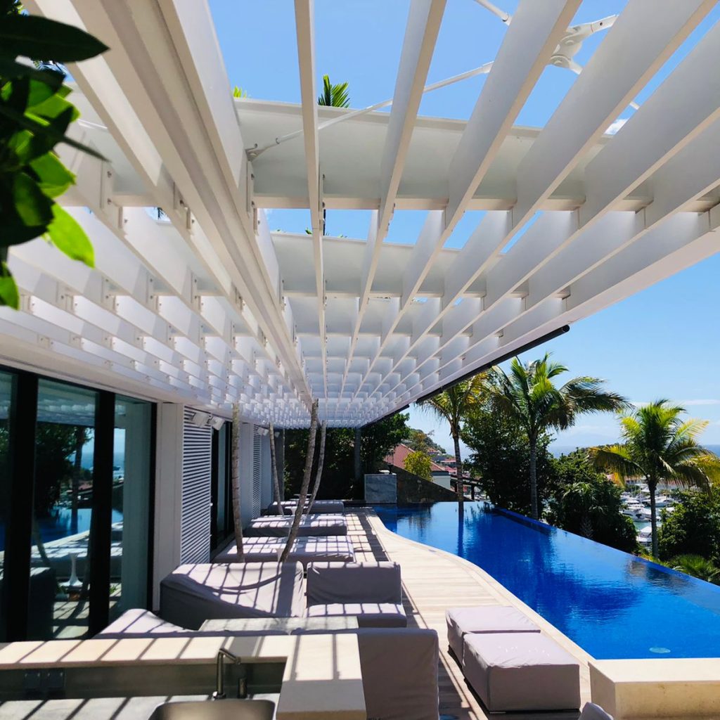 Pergola métallique blanche située au-dessus d'une terrasse extérieure