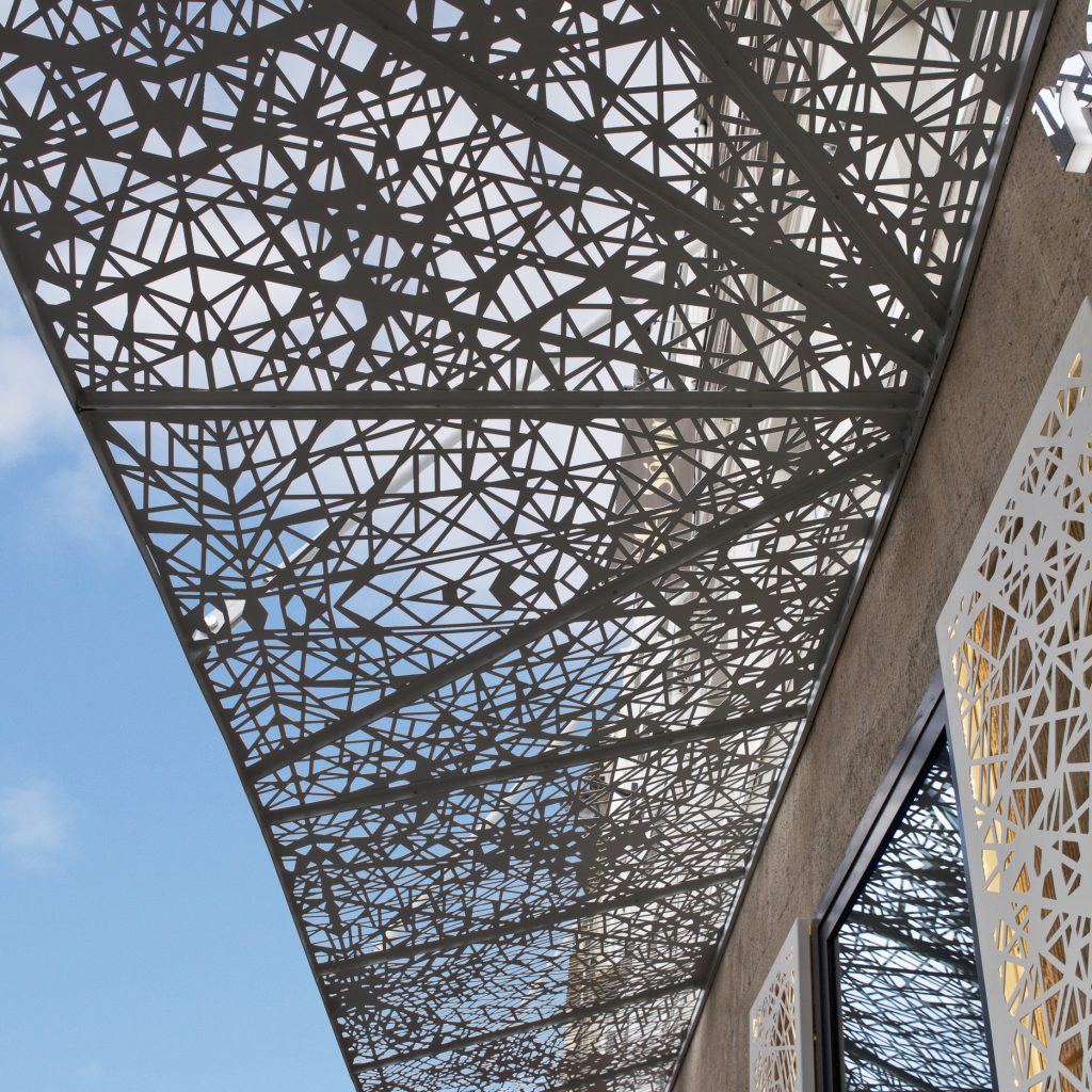 Pergola métallique blanche située au-dessus d'un bâtiment