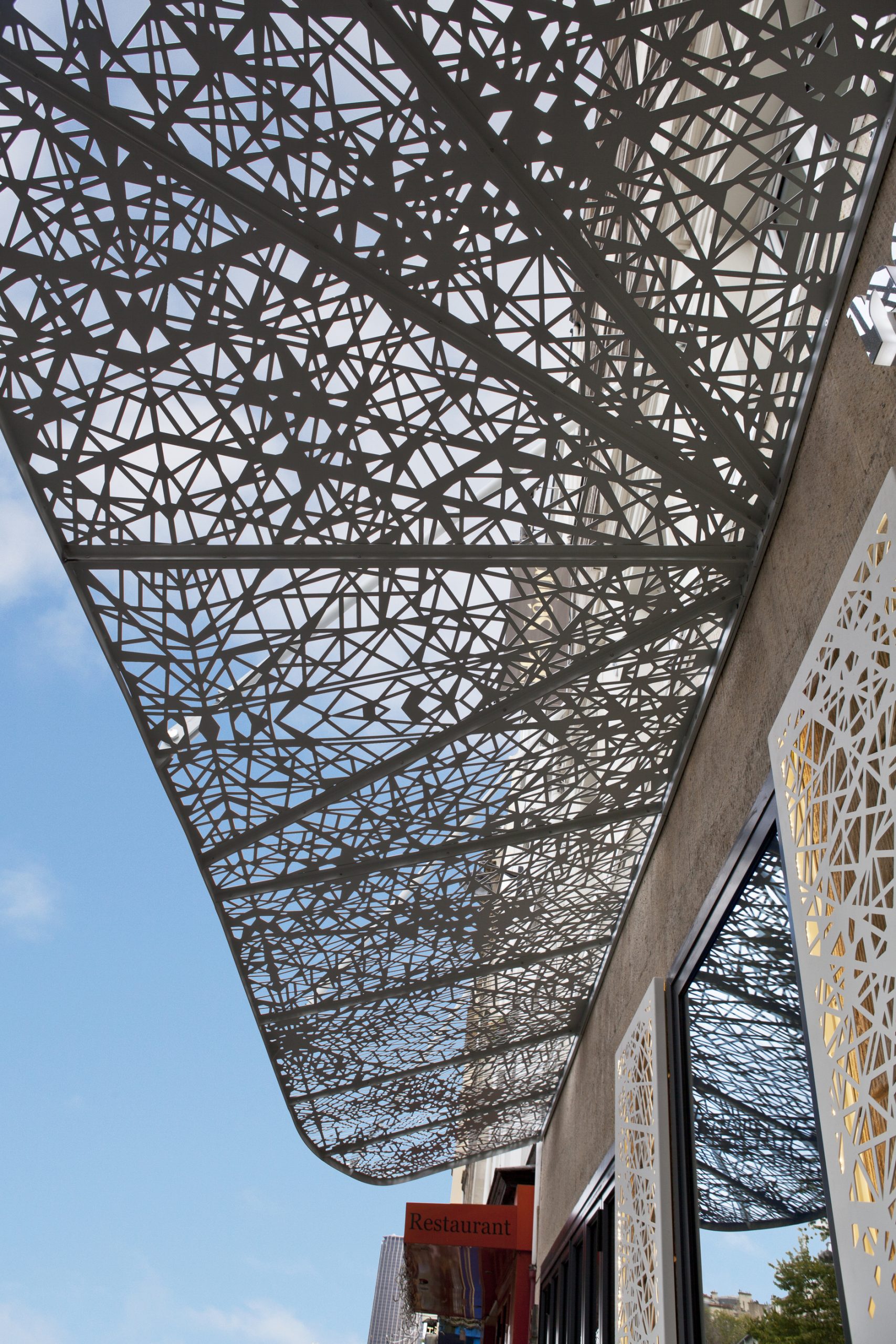 Pergola métallique blanche située au-dessus d'un bâtiment