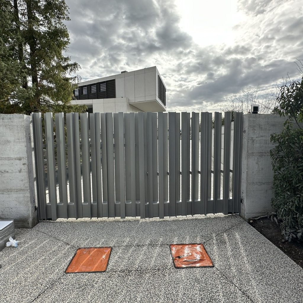 Portail métallique gris installé à l'entrée d'une résidence