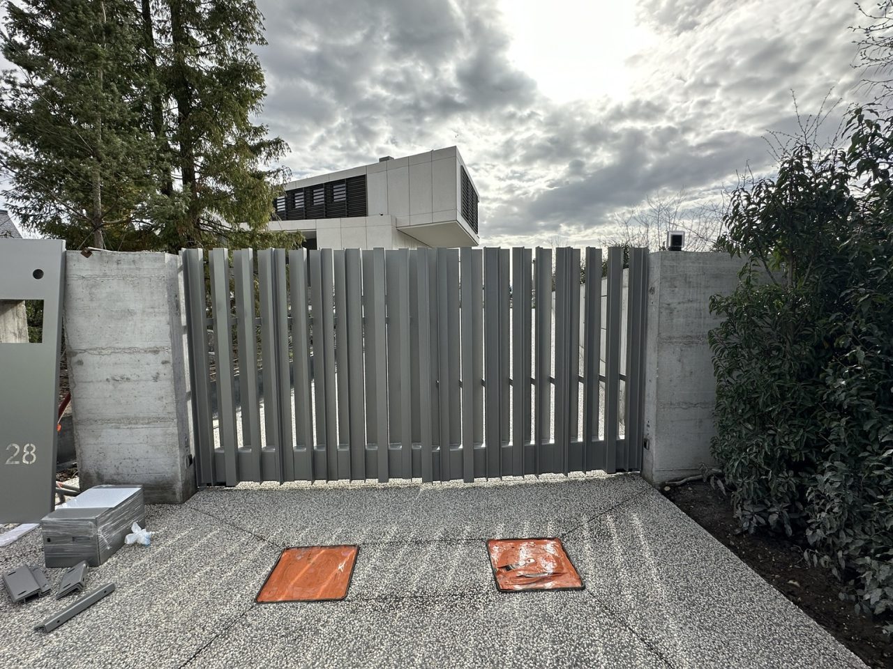 Portail métallique gris installé à l'entrée d'une résidence