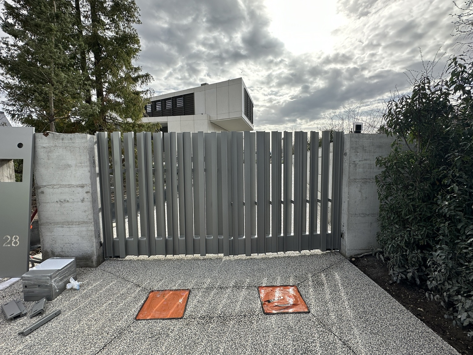 Portail métallique gris installé à l'entrée d'une résidence