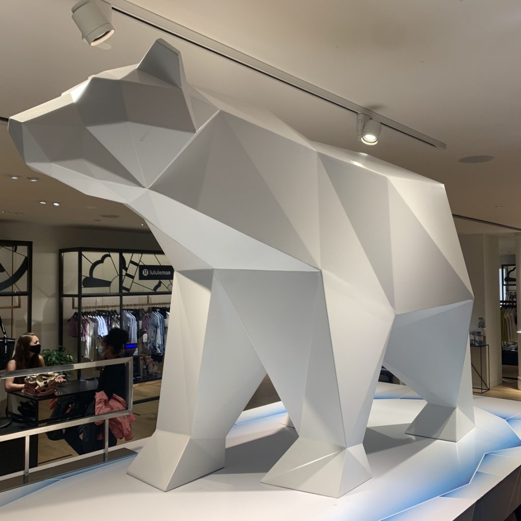 Sculpture métallique blanche représentant un ours polaire située dans un magasin de vêtements