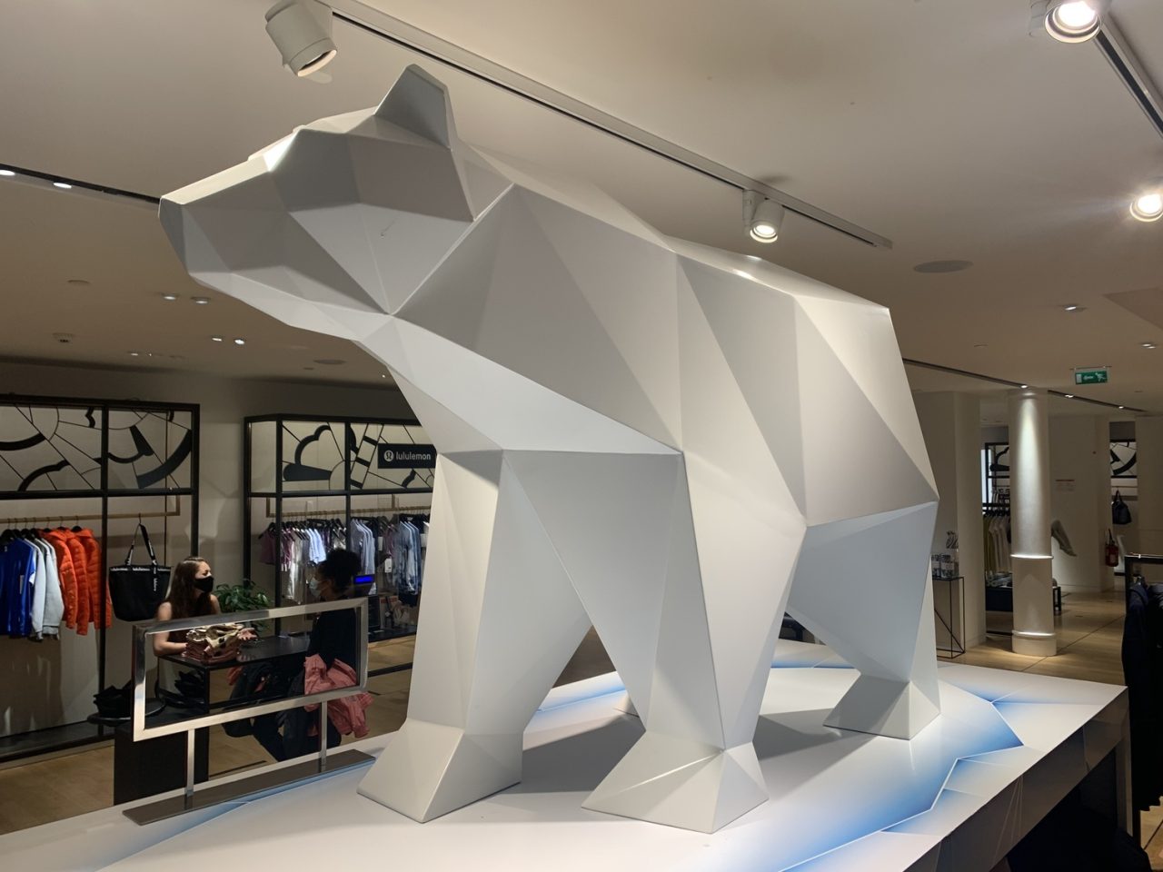 Sculpture métallique blanche représentant un ours polaire située dans un magasin de vêtements